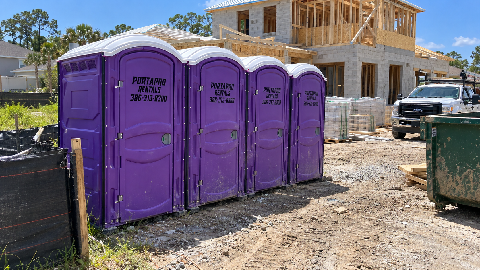 PortaPro purple porta potty units lined up on an active residential construction site